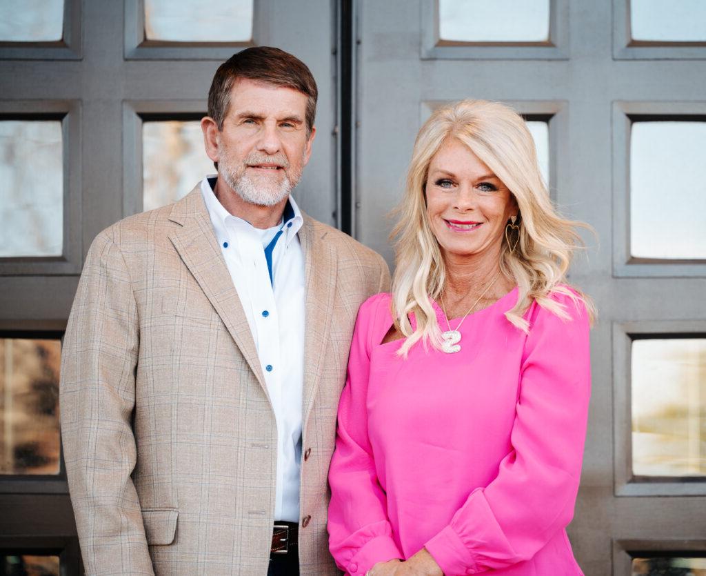 JR & Susan Emrich standing in front of doors at SNU